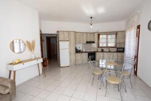 a kitchen with a table and chairs in a room at Anemoessa in Ammoudia