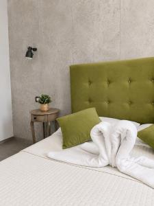 a bedroom with a bed with a green headboard at Affitti Brevi SCALA DEI TURCHI in Realmonte