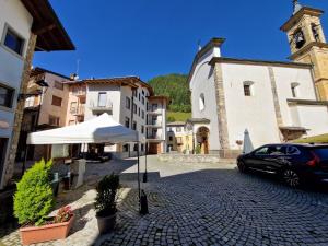 a car parked next to a building with a white umbrella at B&B Scarpo & Supel in Nona