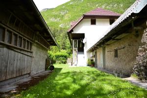 an alley between two buildings with a green yard at Apartma Kukč II in Bovec