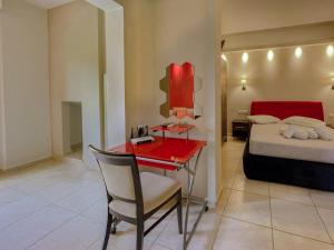 a bedroom with a bed and a desk with a red table at Octopus in Vasiliki +21 photos