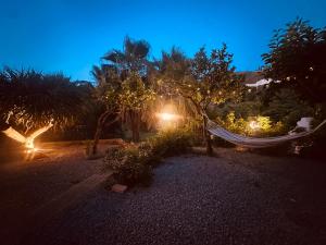 a hammock in a garden at night with lights at Villa Tiche in Cefalù