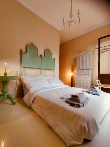 a bedroom with a large white bed with a green headboard at Casa Negrita in Bra