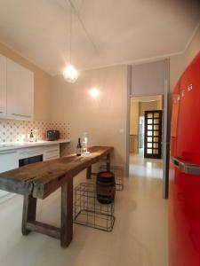a kitchen with a wooden table and a red refrigerator at Casa Negrita in Bra