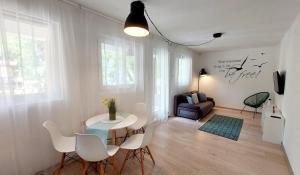 a living room with a table and chairs and a couch at Forest Apartman in Makó