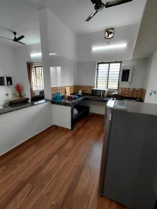 a large kitchen with white walls and wooden floors at AGM Spacious Private AC 1BHK with Hall, Kitchen & Bath in Udupi