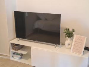 Ein Flachbildfernseher steht auf einem weißen Entertainment-Center. in der Unterkunft Elia Studios 1 in Nydri