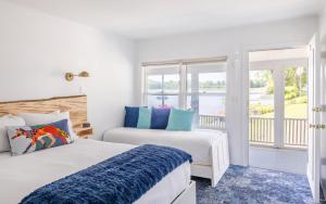 two beds in a room with a window at North Hero House Inn and Resort in North Hero