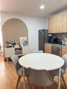 a kitchen with a white table and chairs in a room at OMG Faro in Faro