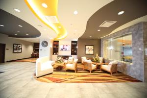 a lobby with a waiting area with chairs and tables at Wyndham Garden Edmonton Airport in Leduc