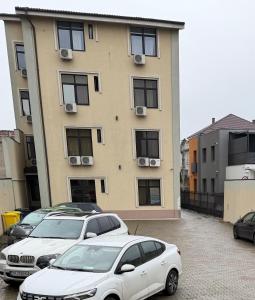 two cars parked in a parking lot in front of a building at MLR Residence - Free Private Parking in Timişoara
