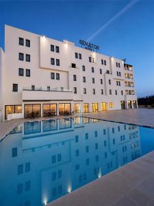 a hotel with a swimming pool in front of it at Hôtel Fnideq Senator in Fnidek