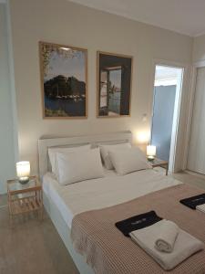 ein Schlafzimmer mit einem großen Bett und zwei Bildern an der Wand in der Unterkunft Elia Studios 1 in Nydri
