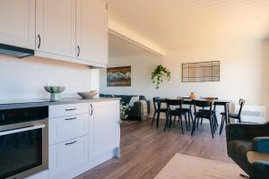 a kitchen and dining room with white cabinets and a table at Sigridhuset in Moskenes