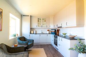 a kitchen with white cabinets and a table and chairs at Sigridhuset in Moskenes