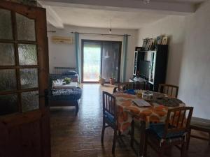 a dining room with a table and chairs and a room with a window at Maison in Tizi Ouzou