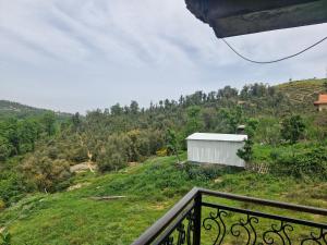 a balcony view of a hill with a white building at Maison in Tizi Ouzou