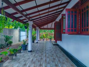 a patio with a wooden floor and a wooden pergola at Venuri Villa Midigama in Midigama East