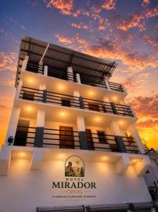 a building with a sunset in the background at Hotel Mirador Creel in Creel