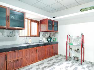a kitchen with wooden cabinets and a tile floor at Venuri Villa Midigama in Midigama East