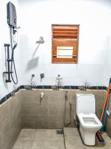 a bathroom with a toilet and a window at Venuri Villa Midigama in Midigama East +40 photos