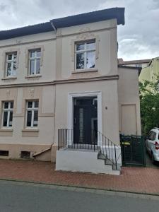 a white house with a black door on a street at FeWoZentrum in Lüdenscheid