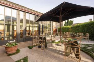a patio with a table and an umbrella and chairs at Le Andrianelle in Malo