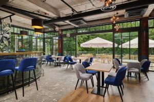 a restaurant with tables and chairs and large windows at Hotel Zator in Zator