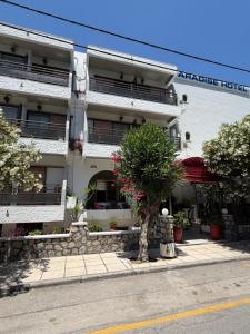 a white building with a tree in front of it at Paradise Hotel in Kos