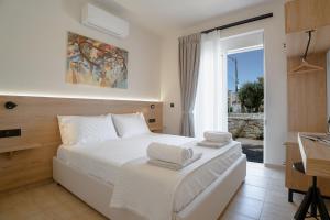 a bedroom with a white bed with towels on it at Marevia in Nopíyia +35 photos