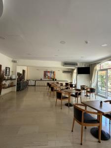 a dining room with tables and chairs and a classroom at Paradise Hotel in Kos