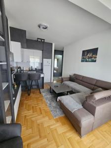 a living room with a couch and a kitchen at Azure Coast in Bar