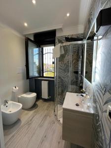 a bathroom with a shower and a sink and a toilet at BRUMARI -Design" moderno, self check-in e parcheggio facile in Foggia +39 photos