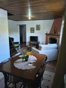 a living room with a table and a bed at Refúgio da Serra - com lareira - 900m do Capivari in Campos do Jordão