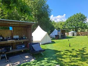 a tent and a chair in a yard with a tent at Route 47 Glamping Bell Tents in Cross Hands