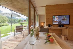 a kitchen and living room with a view of the yard at Relais & Châteaux IN LAIN Hotel Cadonau in Brail