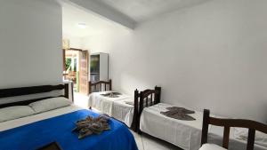 a bedroom with two beds with blue sheets at Hospedagem La Bilbaina in Porto Seguro +45 photos