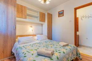 a bedroom with a bed with towels on it at Apartmani Vitković II Cres in Cres
