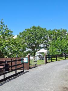 a fence with a gate with a tent in the background at Route 47 Glamping Bell Tents in Cross Hands +4 photos