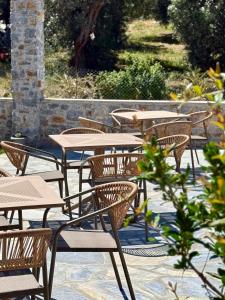 a row of wooden tables and chairs on a patio at Skiathos Bliss Villa in Skiathos