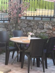 a table and chairs with a stone wall at Къща за гости Пилигрим in Skrino +49 photos