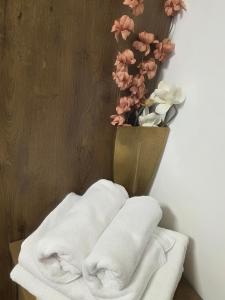a bunch of towels on a shelf with a vase of flowers at Freedom APARTMAN RUMA in Ruma +96 photos