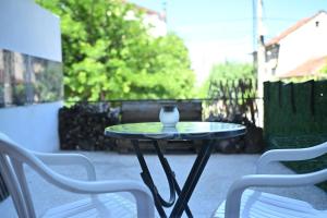 a glass table with a vase on it on a patio at Vintage Blue in Kumanovo