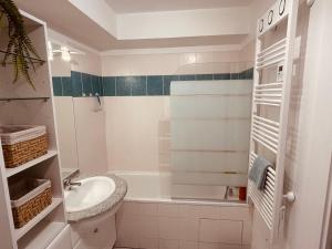 a white bathroom with a sink and a tub at Charmant studio proche gare - parking privatif individuel clos in Arras