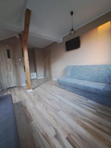 a living room with a couch and a flat screen tv at Windrose in Ustronie Morskie