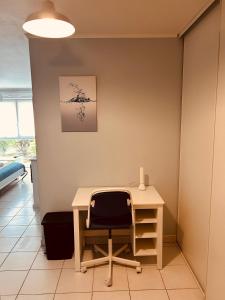 an office with a desk with a chair and a lamp at Charmant studio proche gare - parking privatif individuel clos in Arras