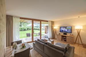 a living room with a couch and a television at Relais & Châteaux IN LAIN Hotel Cadonau in Brail