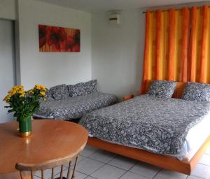 a bedroom with a bed and a couch and a table at Logement entier jardin clos parc chien A1 A29 5 mn in Herleville
