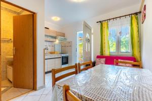 a dining room with a table and a kitchen at Apartmani Vitković II Cres in Cres +42 photos