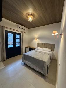 a bedroom with a large bed and a ceiling at Bangalô Hospedagens in São Luís